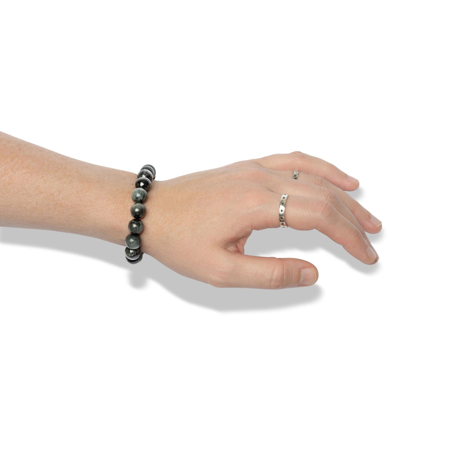 A single crystal gemstone bracelet made of hawk's eye, positioned on a hand adorned with two silver rings.