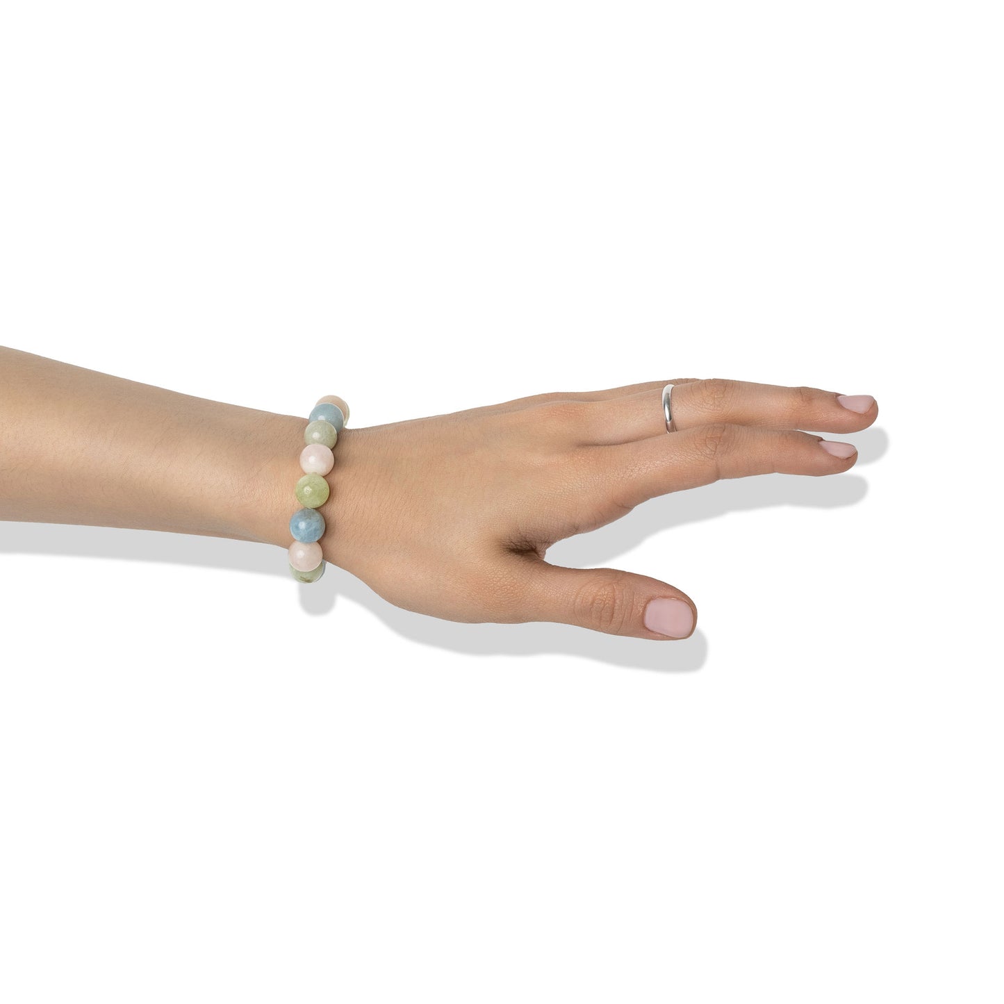 A single crystal gemstone bracelet made of morganite, positioned on a hand adorned with a silver ring and light pink nail polish.