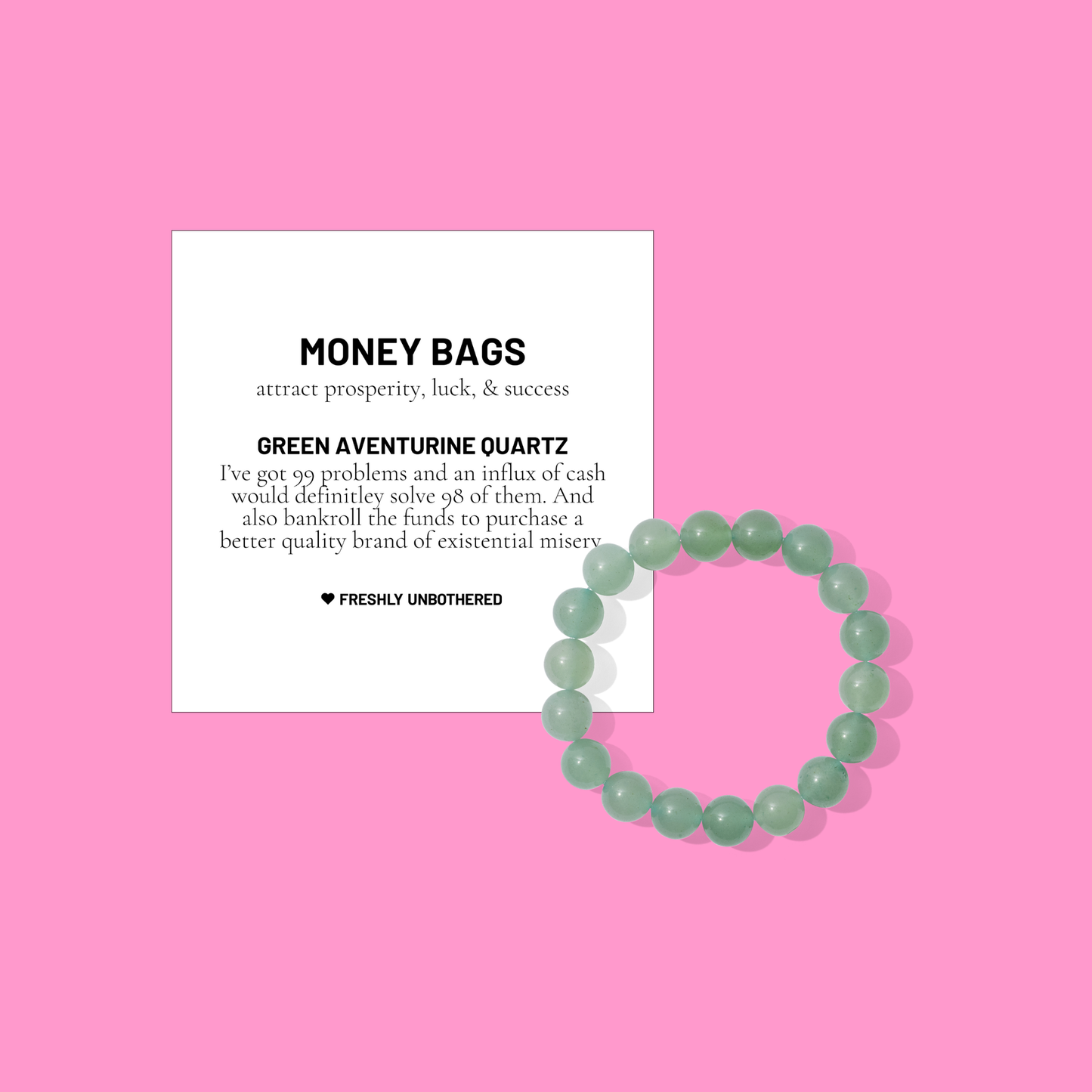 A pink coloured background with a white card bearing the description of a crystal gemstone bracelet, and a round green aventurine quartz bead bracelet, positioned below and to the right of the card.