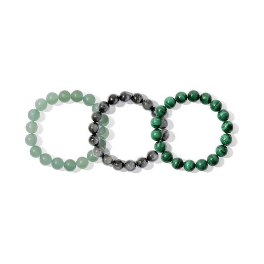 Three crystal gemstone bracelets on a white background. They are a mixture of green and grey colours.