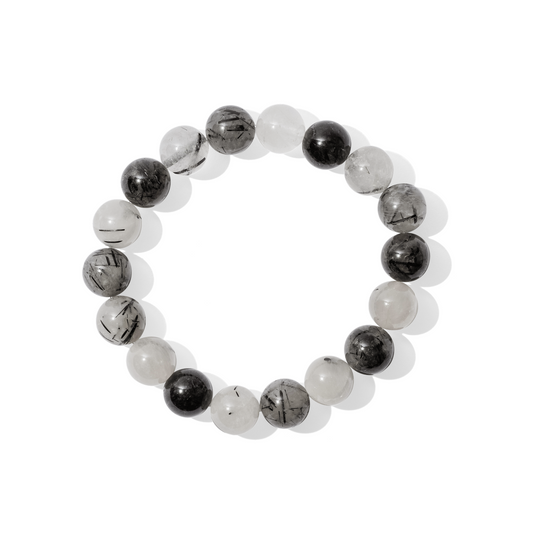 A single crystal gemstone bracelet made of black rutilated quartz. A semi-transparent, shiny mix of white and light grey containing striking black crystals, or rutiles.