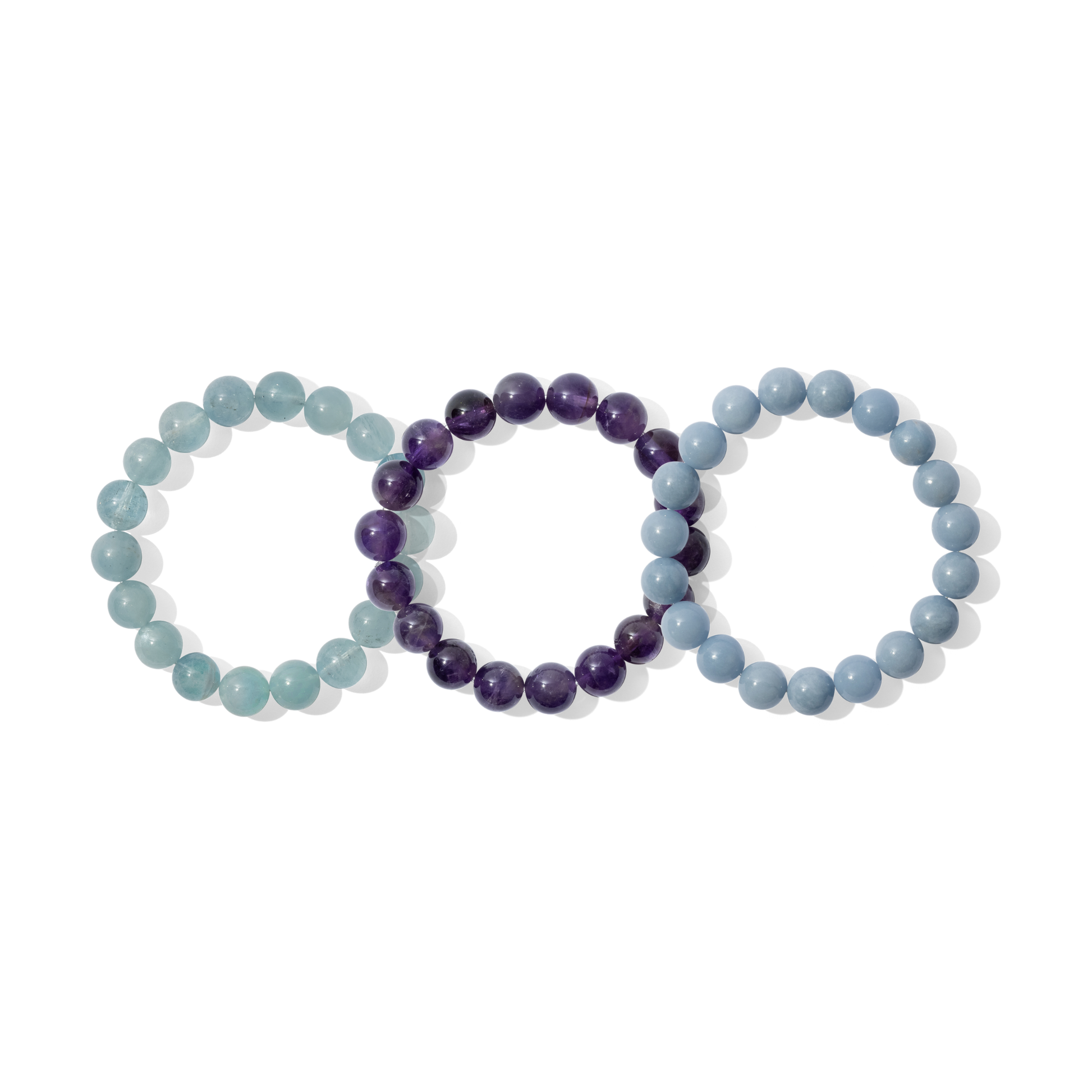 Three crystal gemstone bracelets on a white background. They are a mixture of light blue and purple colours.