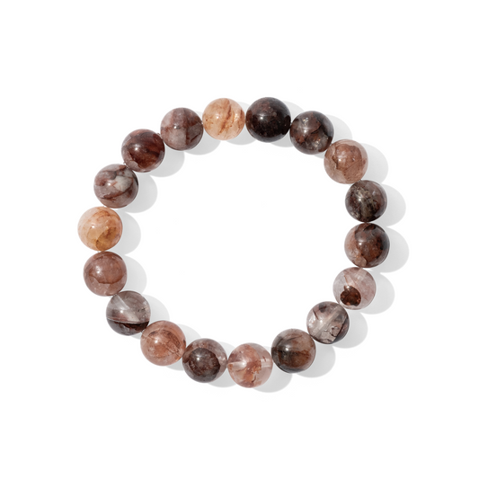 A single crystal gemstone bracelet made of red fire hematoid quartz. A semi-transparent, shiny mixture of white, fiery rust, and deep wine.